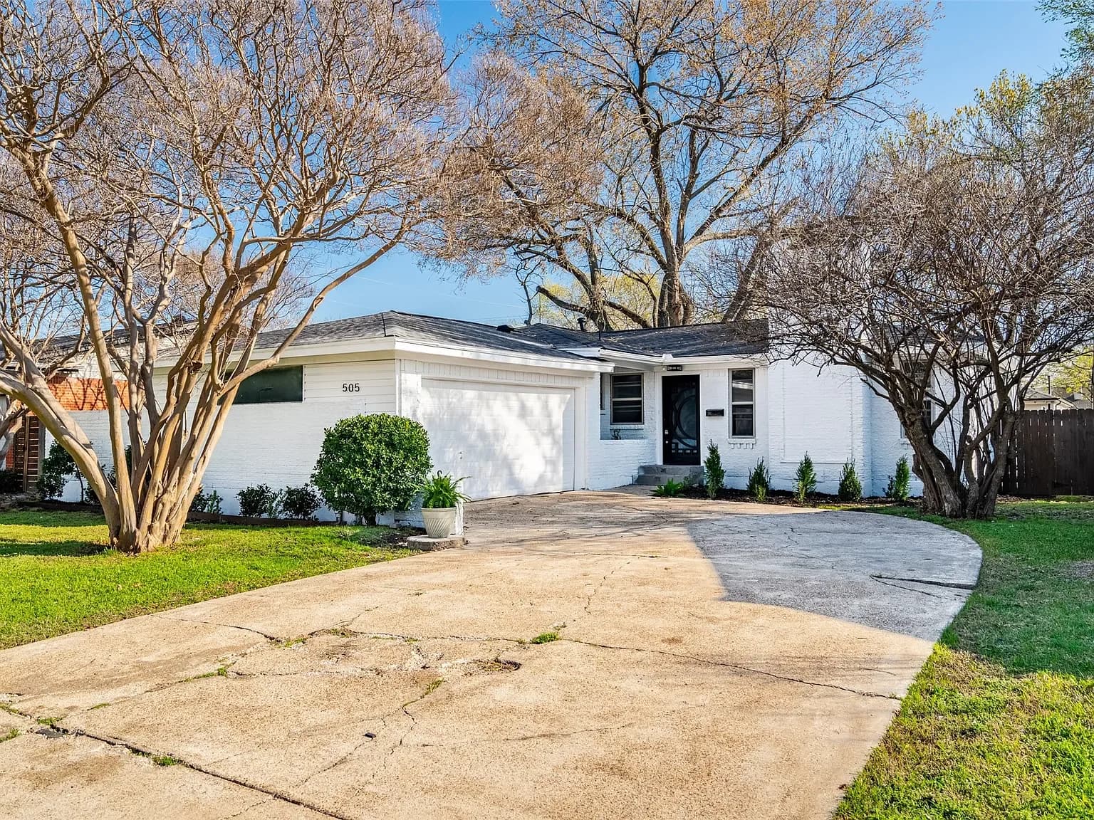 Exterior of a white-painted brick home showing clean rooflines and matched siding